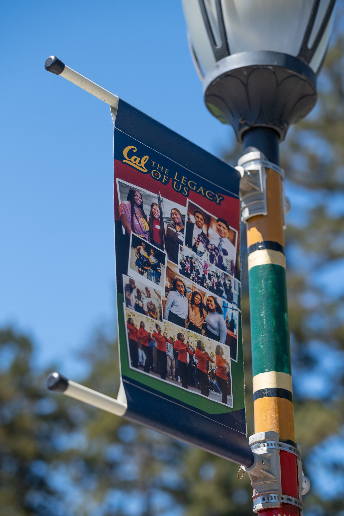 A close up of a sign on a post highlighting photos of the Black community at Cal