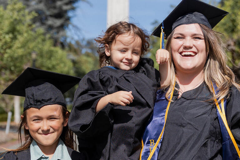 Emily Thompson whos graduating thus may with a BA spends time with her family on campus who are two kids caspain age 2 and river age 10 