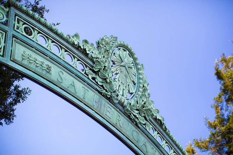 A photo of Sather Gate against a blue sky.