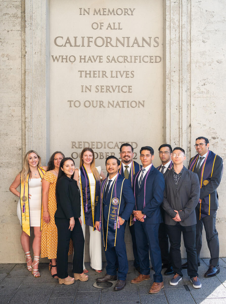 A group of students dressed in regalia in front of Memorial Stadium