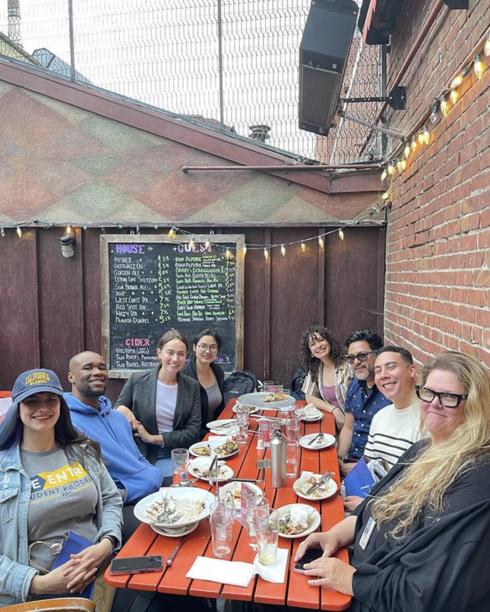 The UC Berkeley Re-entry Peer Advisors sitting around a wooden table eating together.