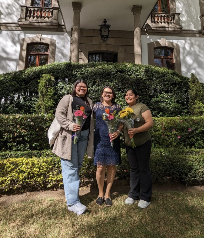 Alexandra Acevedo,  Arlyn Moreno Luna (Education, PhD ‘24)  Gladys Perez (AD, CLSD) posing together in front of an off-white building.