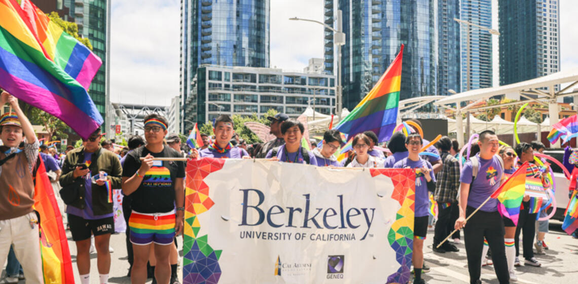Group of Berkeley affiliates at Pride Parade with Berkeley banner and pride flags