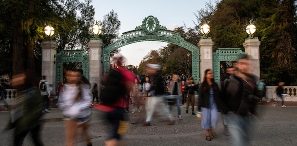 people walking in front of sather gate but its blurry