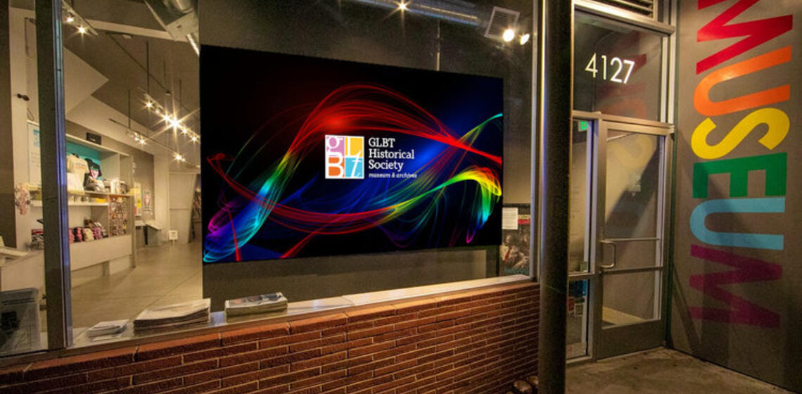 The front door of the GLBT Historical Society Museum with a TV screen and door next to it