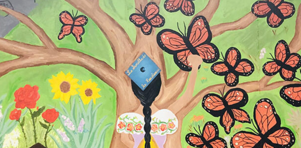 a colorful mural of the back of a person with a long black braid wearing a college graduation cap and looking at a tree surround