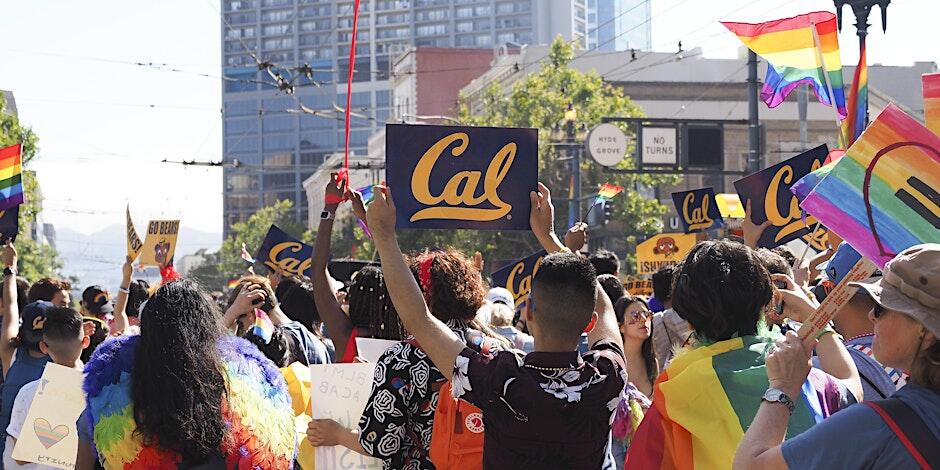 A group of Berkeley students walking at the Pride Parade with Cal/Pride signs